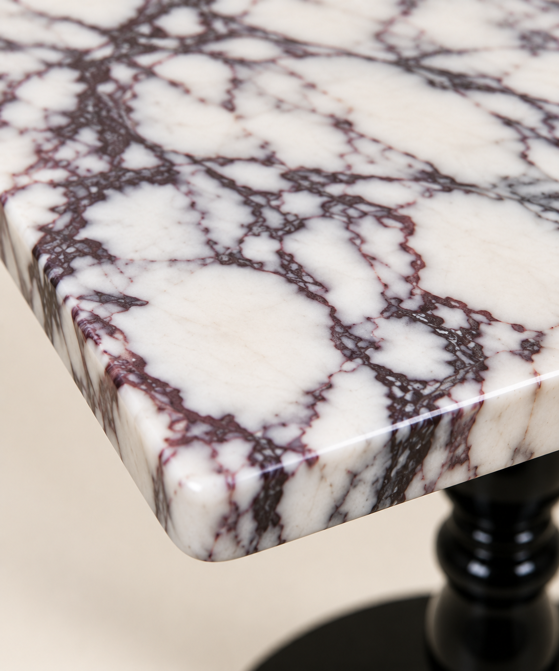 Calacatta Viola marble macro detail showing the veining and polished edge of the square tabletop.