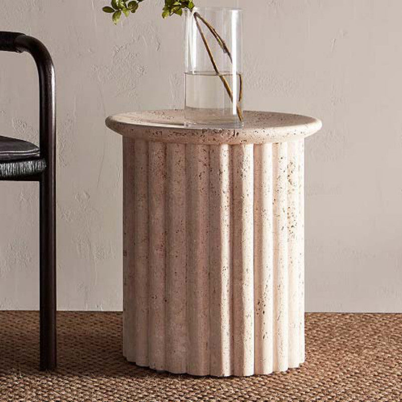 Beige stone side table with a round top and vertically fluted cylindrical base