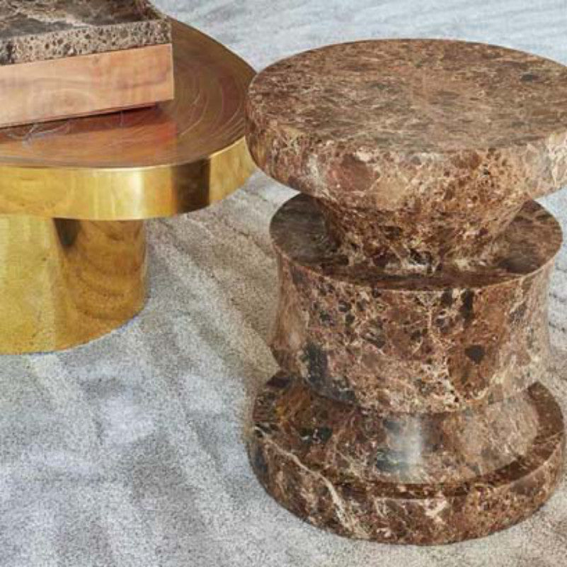 Brown veined stone side table with a rounded top and a column of curved stacked sections