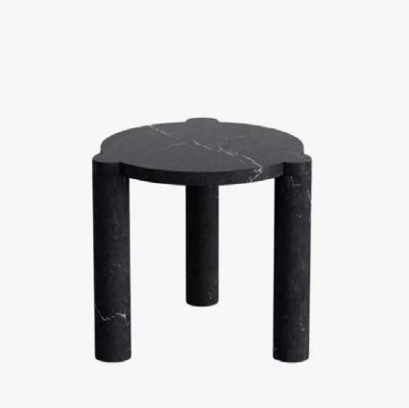Nero Marquina marble side table with a scalloped top and three cylindrical legs, three-quarter view