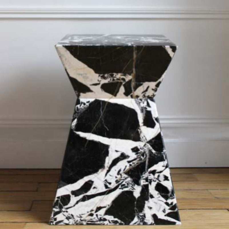 Black and white-veined stone side table with a rectangular top and angular hourglass profile