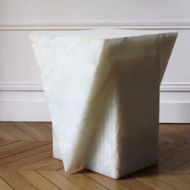 Pale stone side table with a broad rectangular top and tapered intersecting slab supports