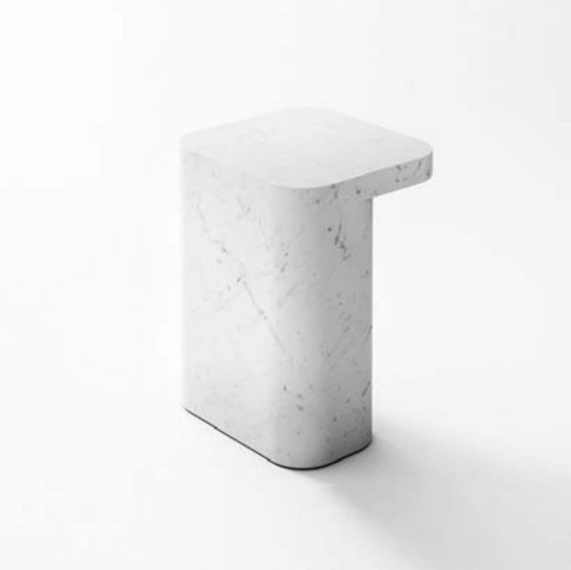 Pale stone side table with a square top and broad curved slab pedestal