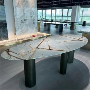 Oval veined stone dining table with dark cylindrical legs in a showroom
