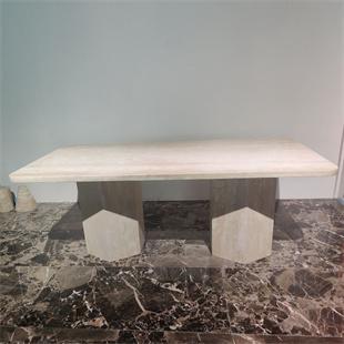 Rectangular pale stone dining table with two faceted supports, front view