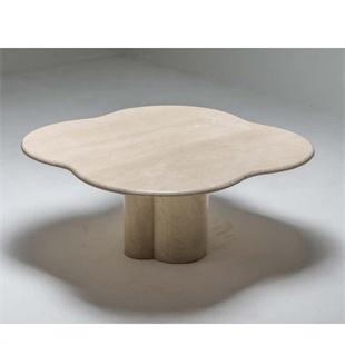 Stone dining table with a lobed top and clustered cylindrical supports, three-quarter view