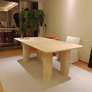 Rectangular pale stone dining table with rounded corners and four legs in a dining room