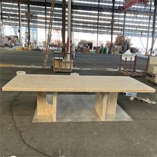 Rectangular stone dining table with two open supports in a workshop