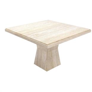 Square pale stone dining table with a tapered pedestal, three-quarter view