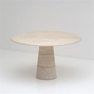 Round pale stone dining table with a tapered pedestal, front view