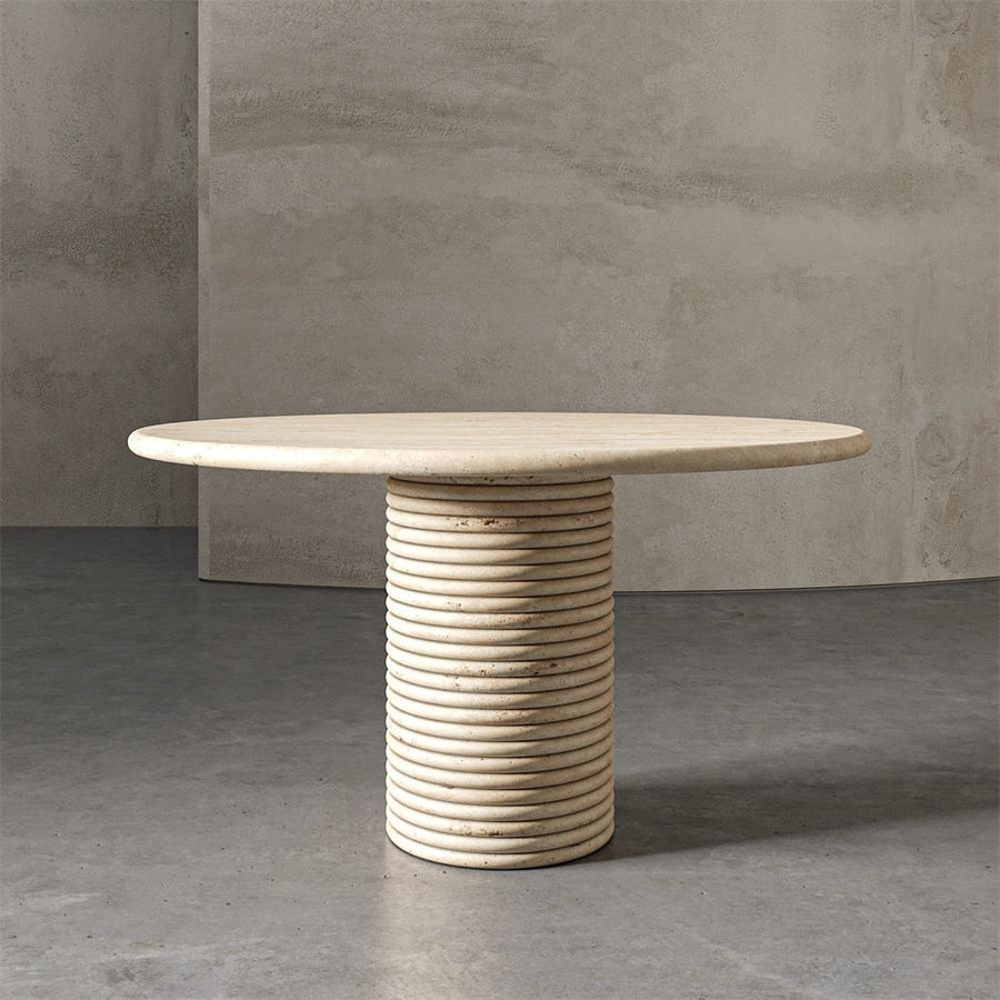 Round pale stone dining table with a horizontally ribbed cylindrical pedestal