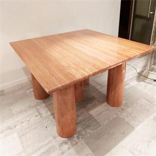 Square reddish stone dining table with cylindrical legs, viewed from above