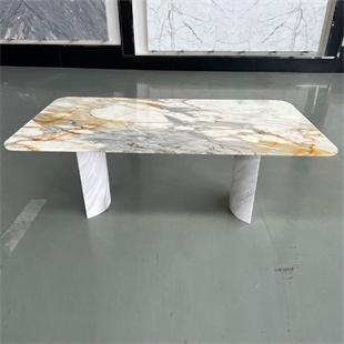 Rectangular veined stone dining table with rounded corners and two pale supports