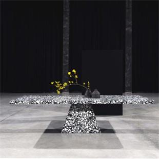 Black and white patterned stone dining table with a tapered pedestal, front view