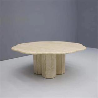 Pale stone coffee table with an irregular rounded top and clustered vertical slab supports