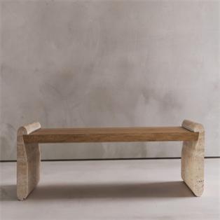 Long table with a brown slatted top and two pale stone end supports against a grey wall