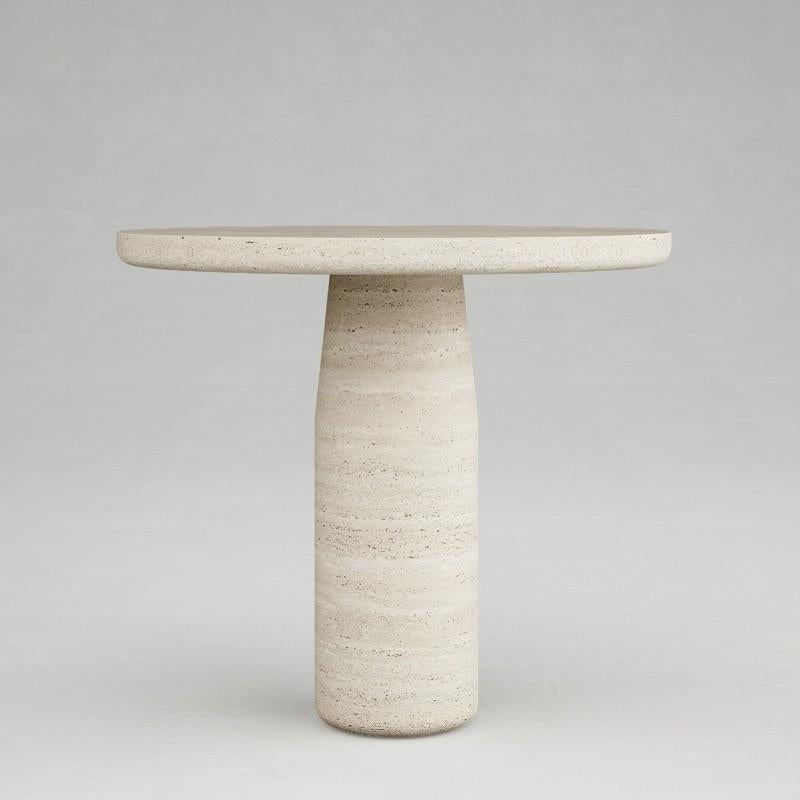 Round pale stone dining table with a tapered cylindrical pedestal, front view