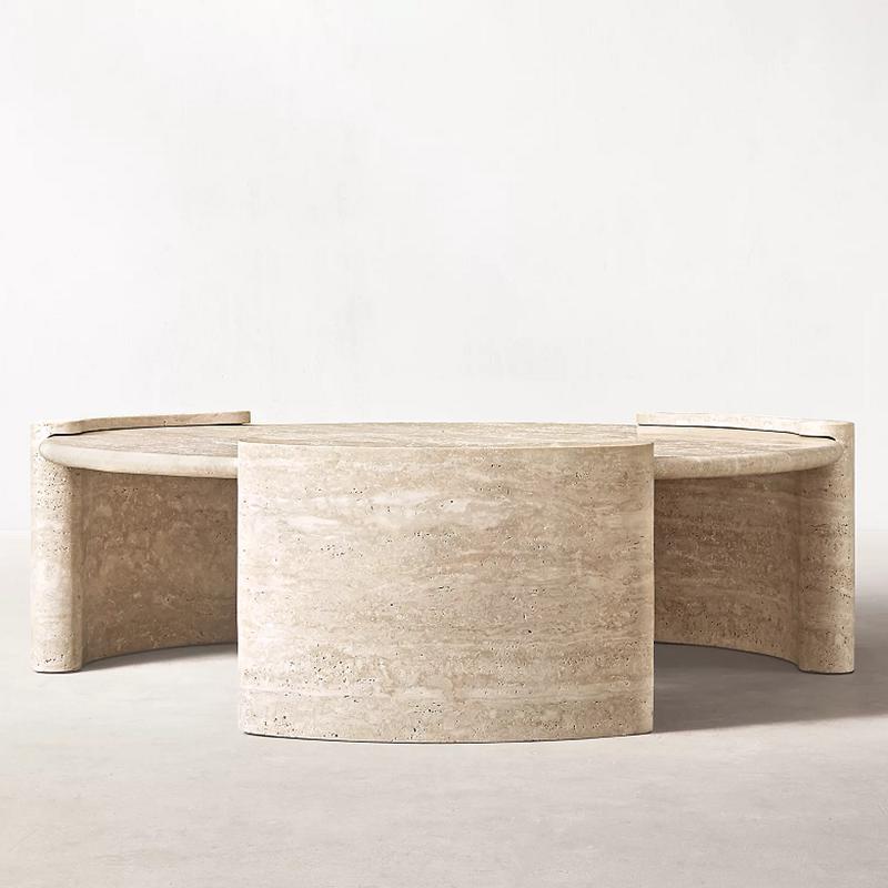Round pale stone coffee table with curved slab supports and raised edges, front view