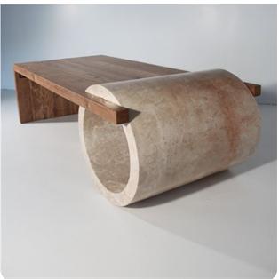 Sculptural coffee table with a rectangular slab and a large hollow stone cylinder, three-quarter view