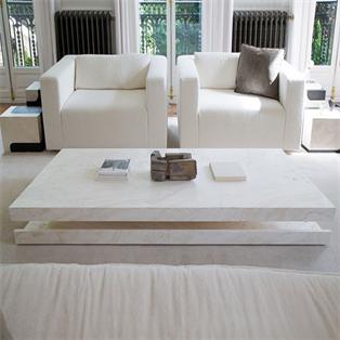 Rectangular pale stone coffee table with an open lower section in front of two armchairs
