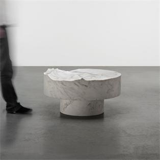 Round pale veined stone coffee table with a sculpted uneven top and recessed base