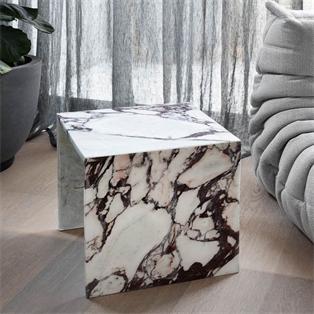 Square strongly veined stone block side table beside an armchair