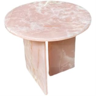 Round pink stone side table with intersecting slab supports, viewed from above