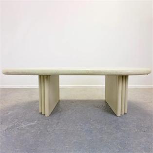 Rectangular pale stone coffee table with rounded corners and folded slab supports, front view
