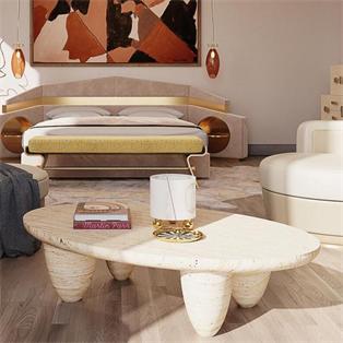 Pale stone coffee table with an undulating top and rounded legs in a living room