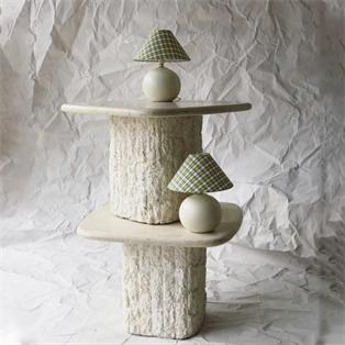 Two pale stone tables with rough-textured cylindrical supports and lamps, room view