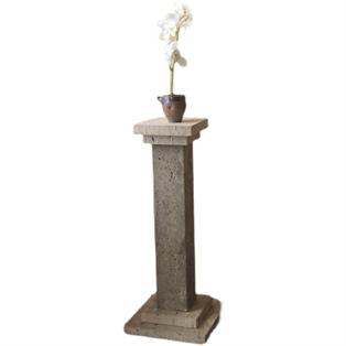 Tall stone pedestal with a square top and stepped base supporting a potted plant