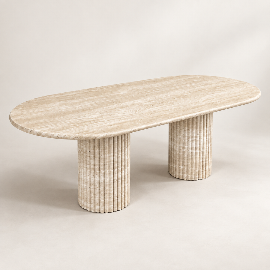 Oval Light Beige Travertine Dining Table in a three-quarter studio view with two fluted cylindrical pedestal legs.