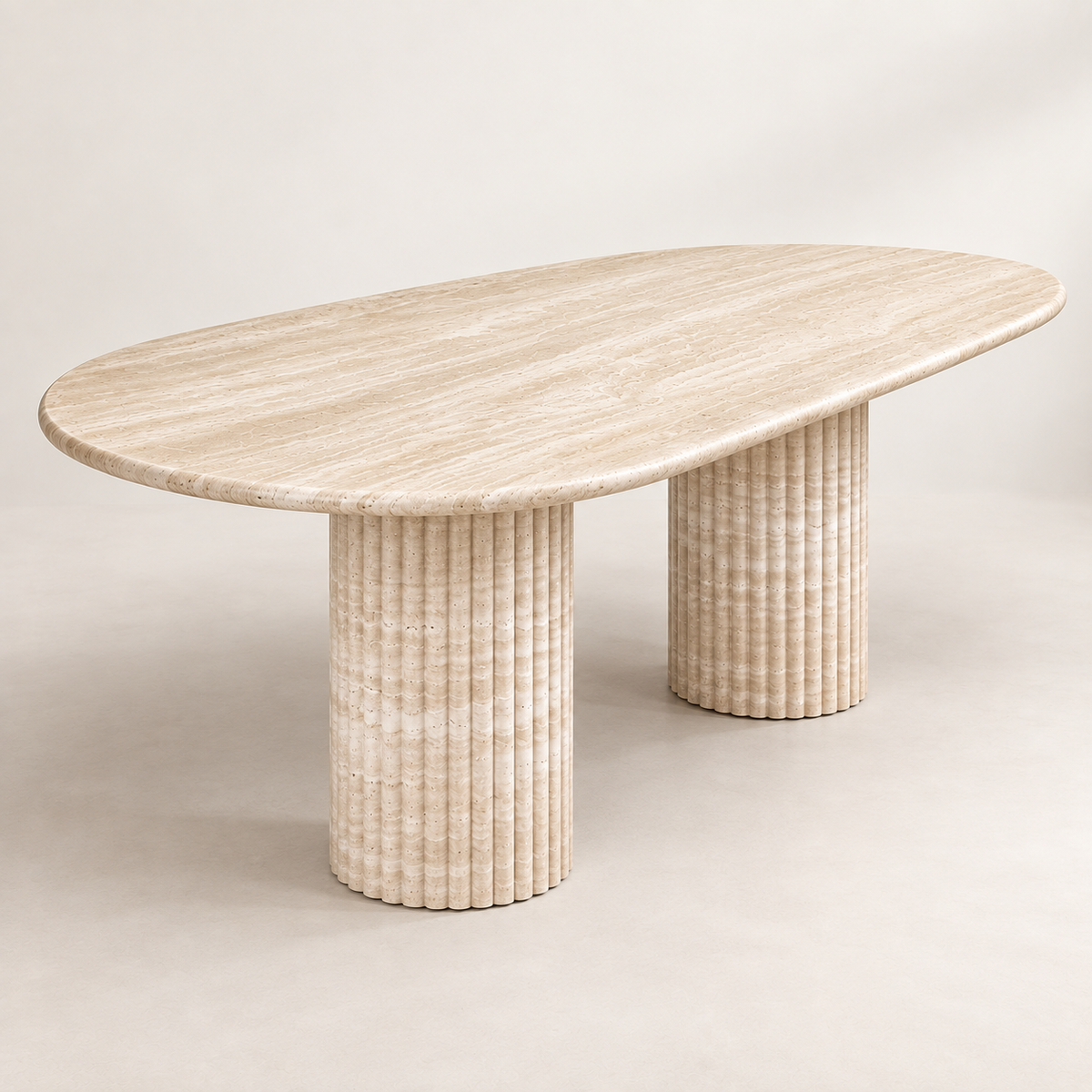 Oval Light Beige Travertine Dining Table from a low opposite three-quarter angle showing both fluted pedestal legs.