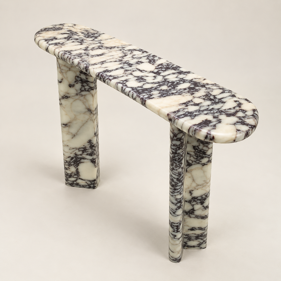 Viola marble console table in Turkish Calacatta Viola, three-quarter studio view showing the slim rounded top and two stone supports.