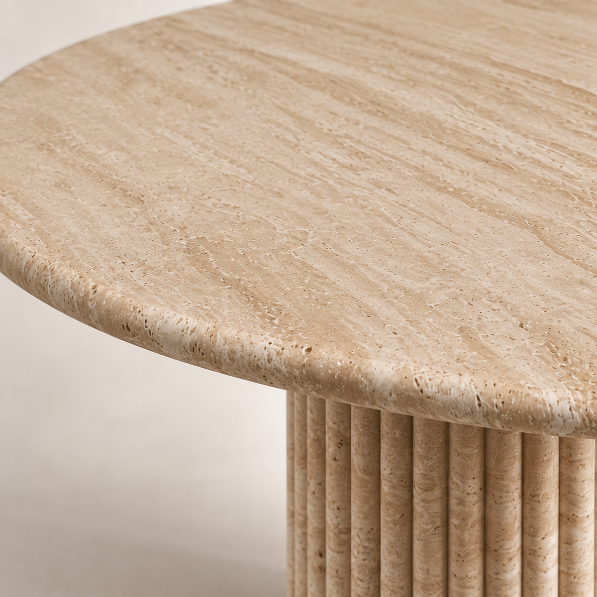 Close-up of light beige travertine tabletop, rounded edge and fluted pedestal detail