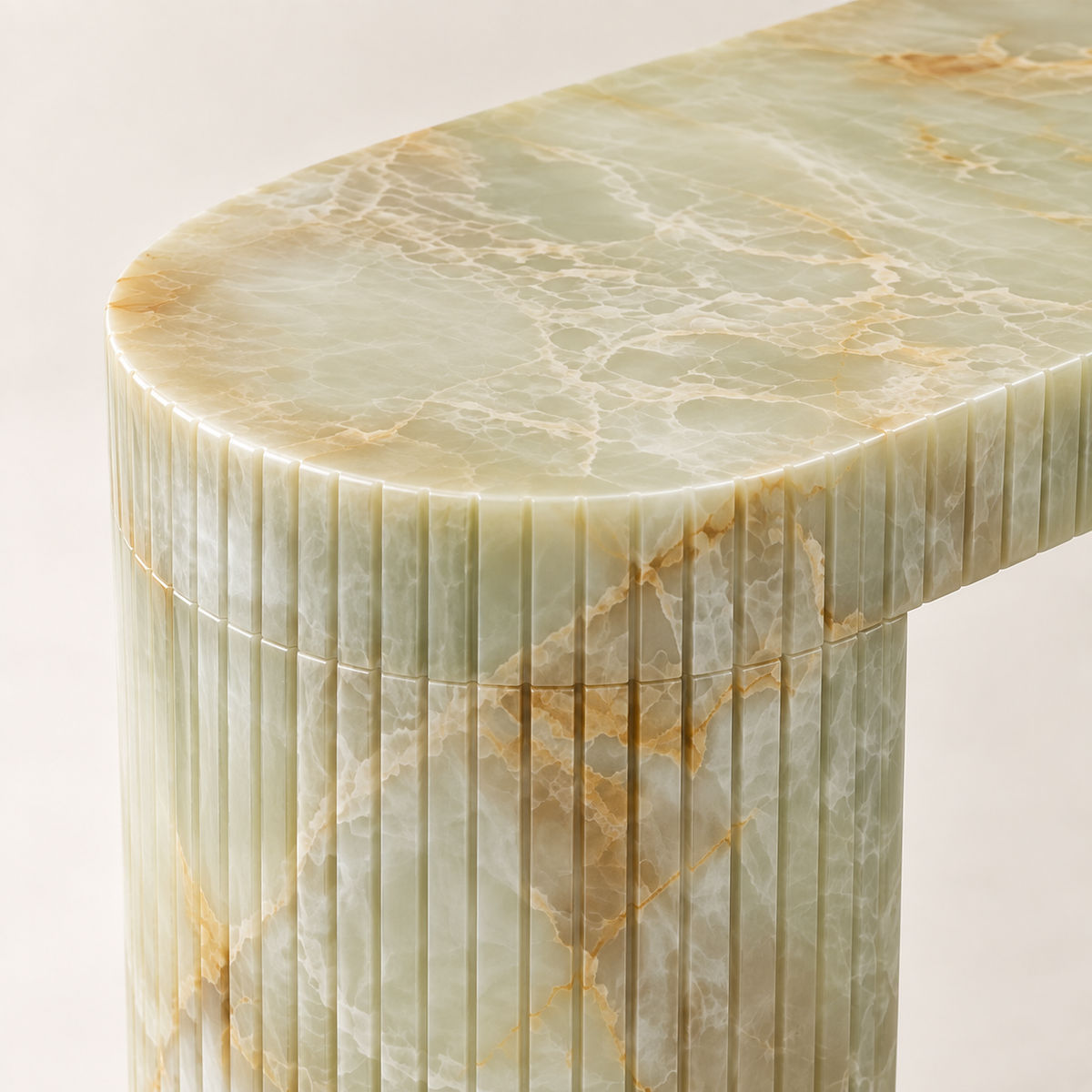 Close-up of the rounded pale green onyx edge and vertically fluted curved support of Console Table MS-10.