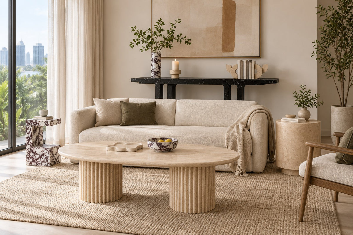 Living room with a fluted travertine coffee table, two stone side tables and a black marble console