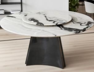 Round stone dining table with a veined top and dark pedestal, three-quarter view