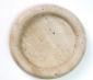 Round beige stone tray with a raised rim, viewed from above