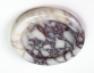 Round pale stone tray with dark purple veining and a raised rim, viewed from above