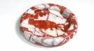 Round red and white veined stone tray with a raised rim, viewed from above