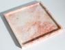 Square pink stone tray with a raised rim, three-quarter view