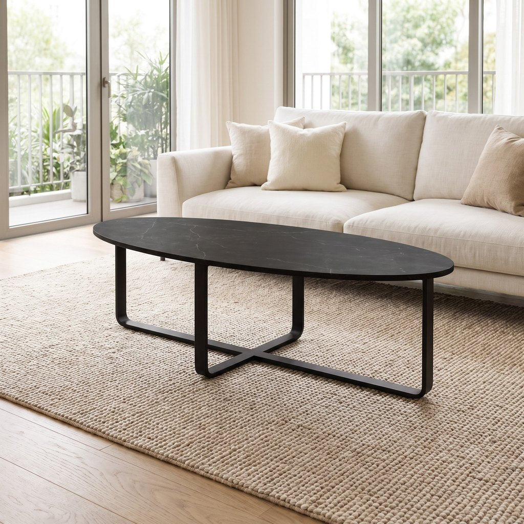 Oval Black Marble Coffee Table — Metal Cross Base, in a living room